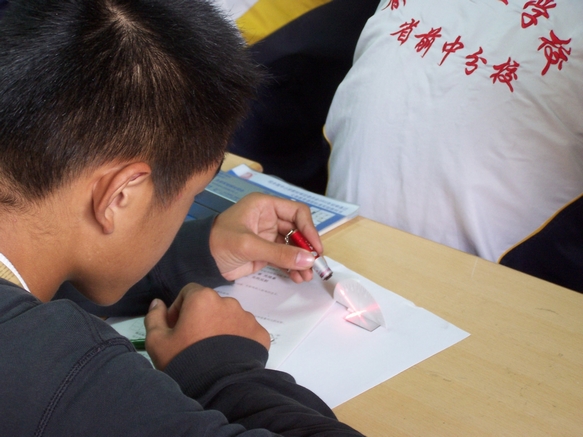 学生在用光学实验探究组合器材自主进行光的反射规律的探究